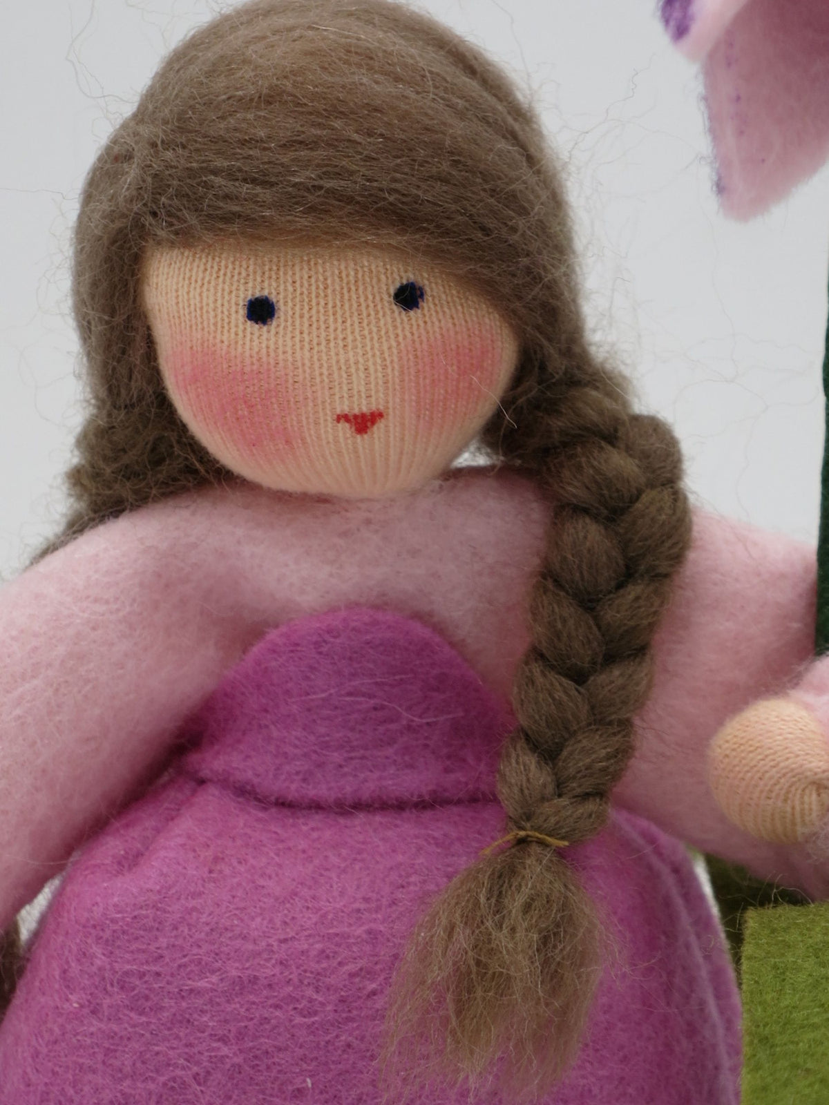 Nahaufnahme des Gesichts der Schachbrettblumen-Figur mit geflochtenem Zopf.