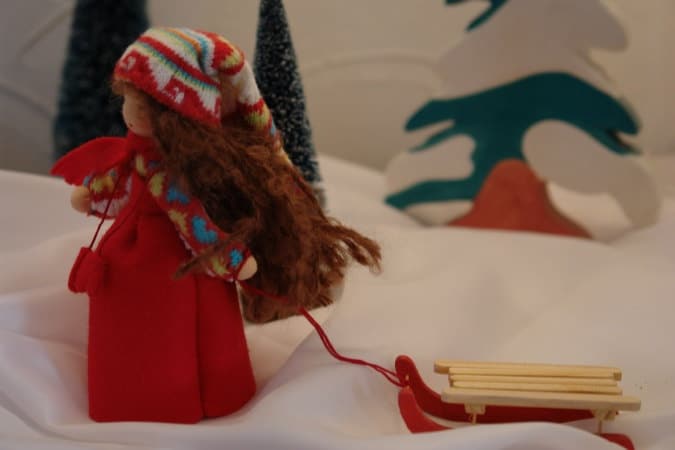 Schlittenmädchen Blumenkind mit rotem Mantel und Norweger-Mütze auf Holzschlitten, Waldorf Jahreszeitentisch Art. WI18
