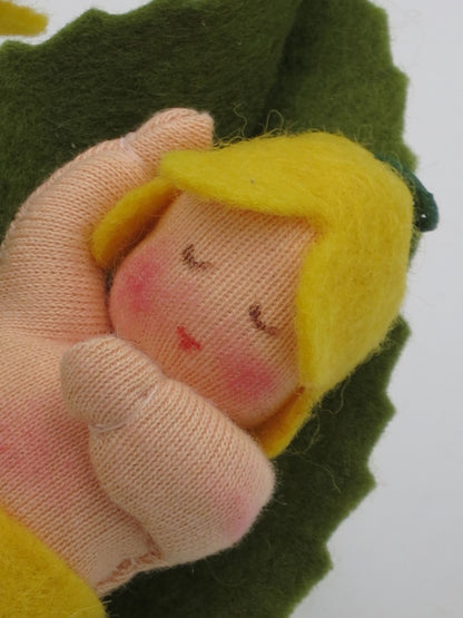 Nahaufnahme des schlafenden Schlüsselblumen-Baby-Gesichts im grünen Blatt