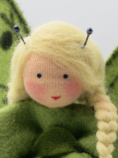 Nahaufnahme des Schmetterling-Blumenkind-Gesichts mit Draht-Fühlern und blondem Zopf