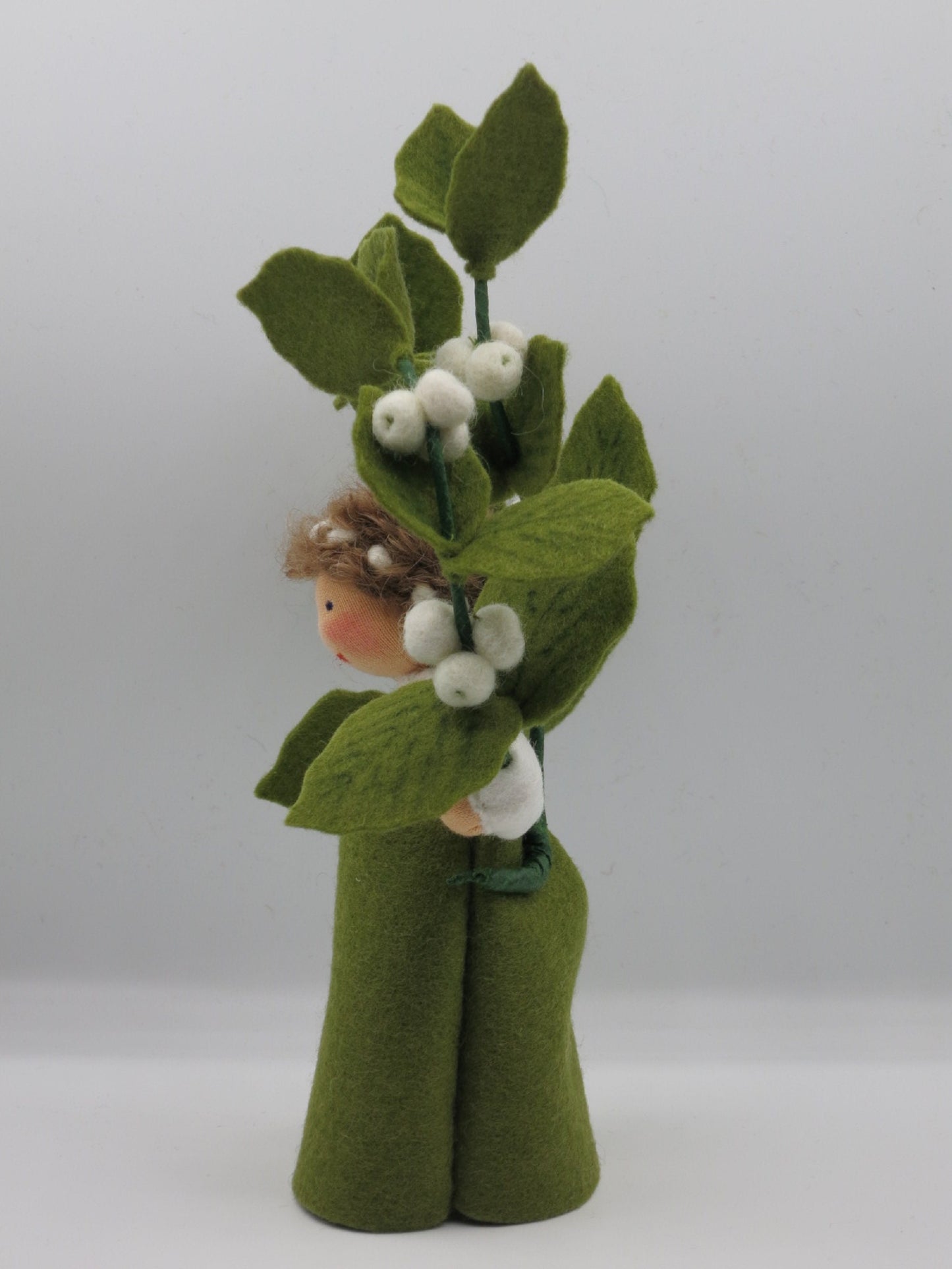 Seitenansicht der Schneebeere Art. HE57 mit hochgehaltenem Zweig aus weißen Filzbeeren, Waldorf-Blumenkind Herbst.