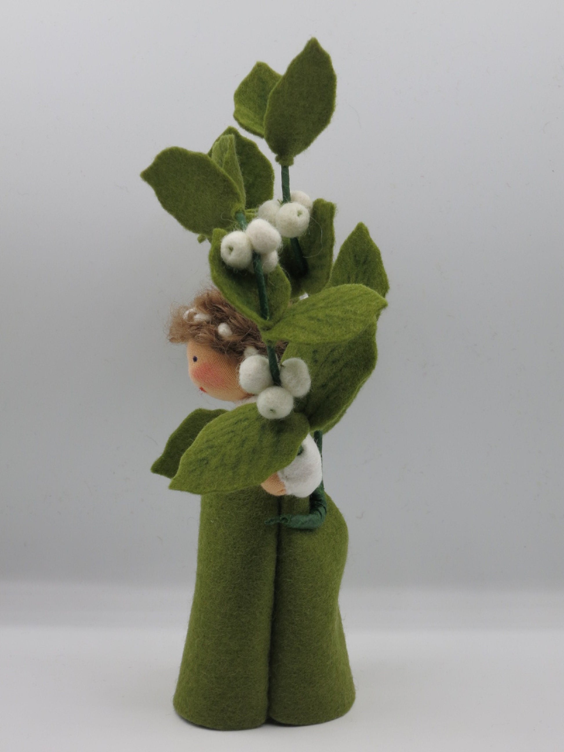 Seitenansicht der Schneebeere Art. HE57 mit hochgehaltenem Zweig aus weißen Filzbeeren, Waldorf-Blumenkind Herbst.