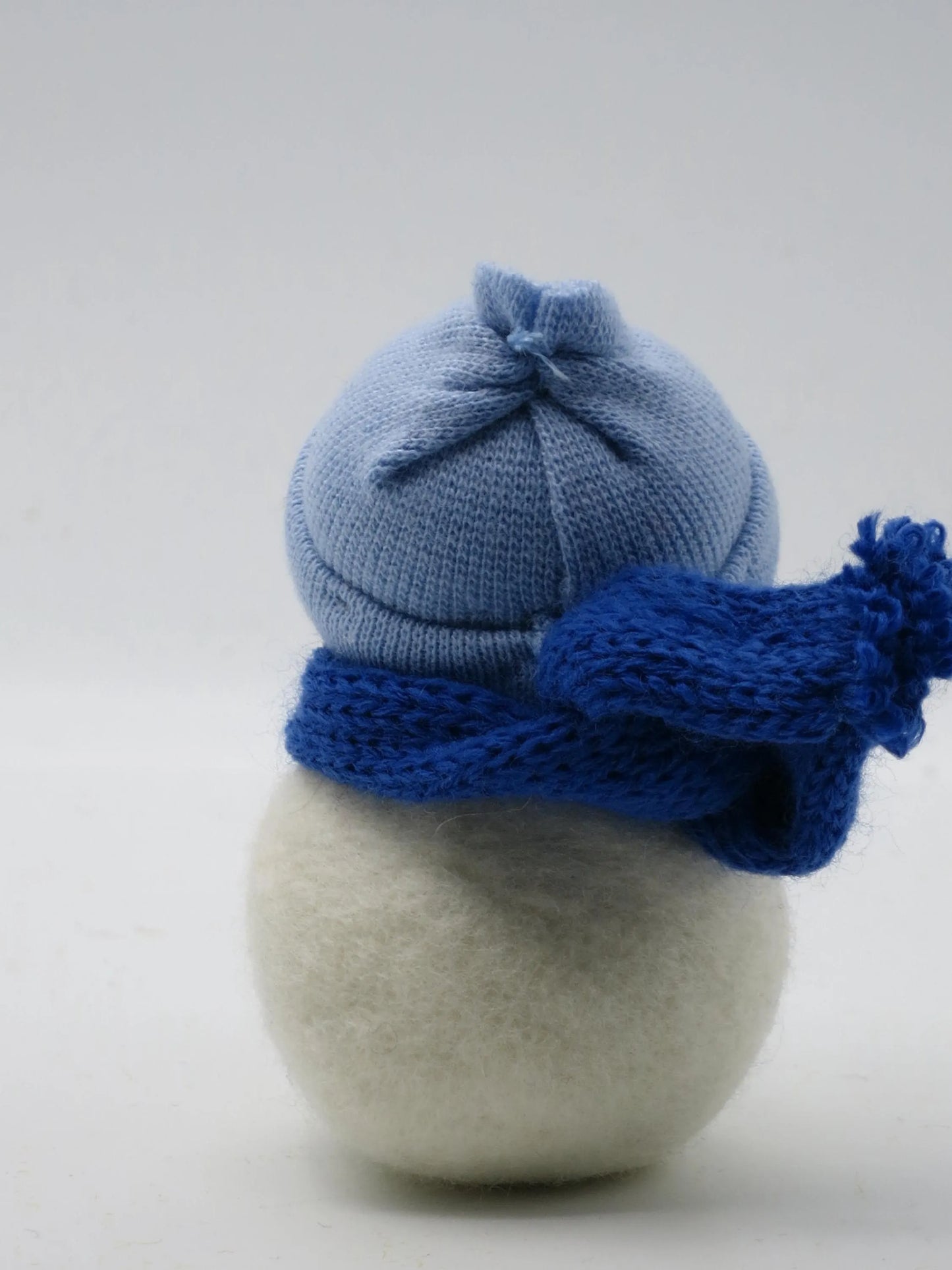 Nassgefilzter Schneemann in Blau, Rückansicht mit gestrickter Mütze und Schal – Waldorf-Blumenkind für den Jahreszeitentisch, Art. WI4