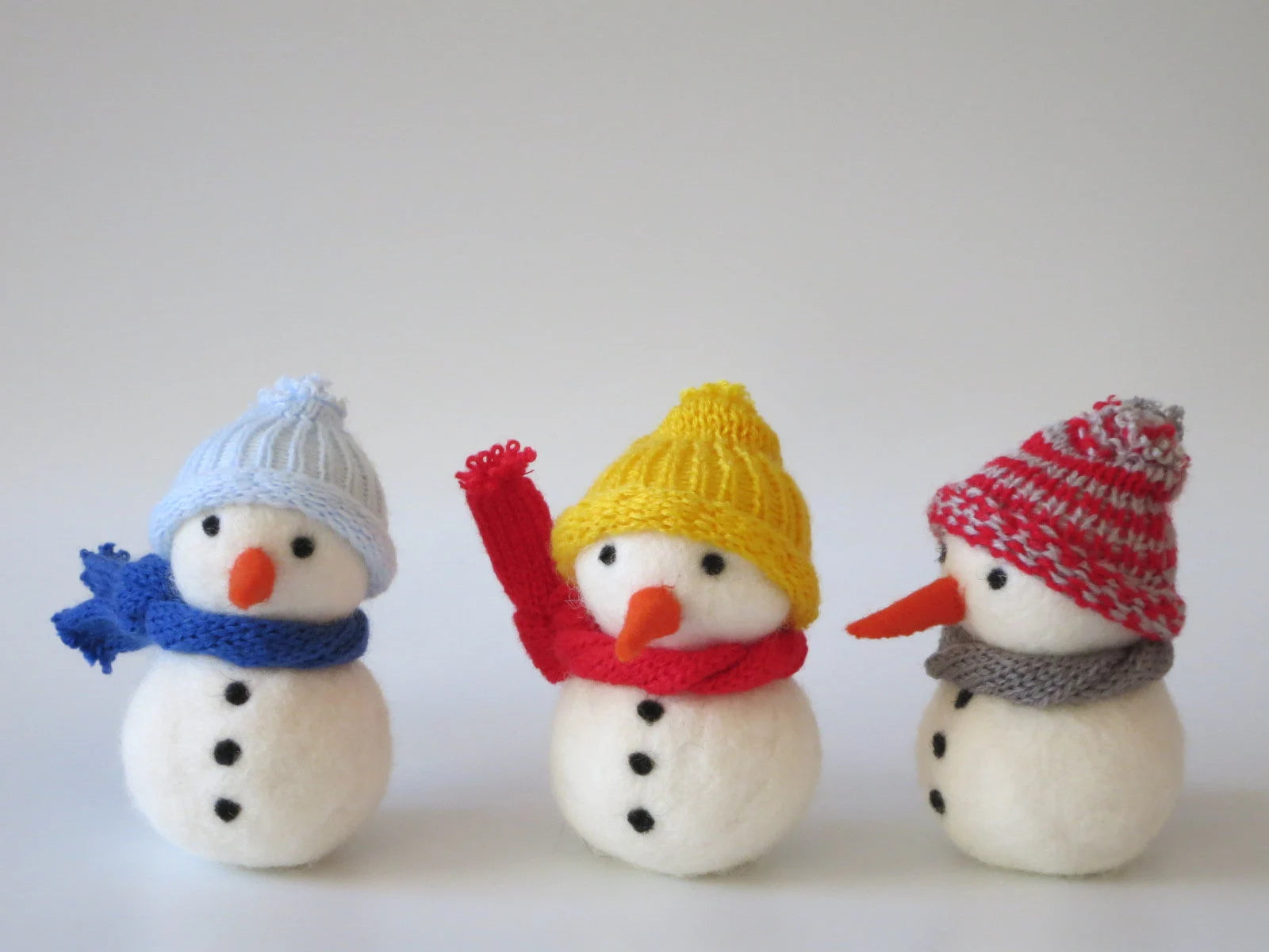 Nassgefilzte Schneemänner in Blau, Rot und Gelb mit gestrickter Mütze und Schal – Waldorf-Blumenkind für den Jahreszeitentisch, Art. WI4