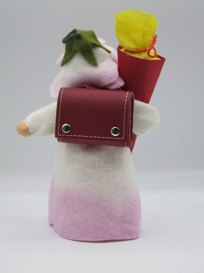 Rückansicht des Schulmädchen-Blumenkinds mit rotem Schulranzen und Schultüte mit gelbem Füllpapier.