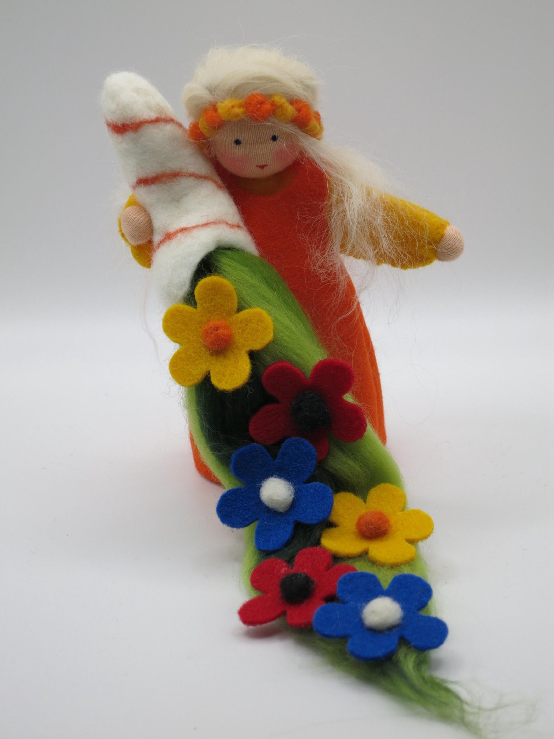 Sommer-Blumenkind mit orangefarbenem Gewand, hellem Filzzweig und langem Blumenteppich in kräftigen Sommerfarben