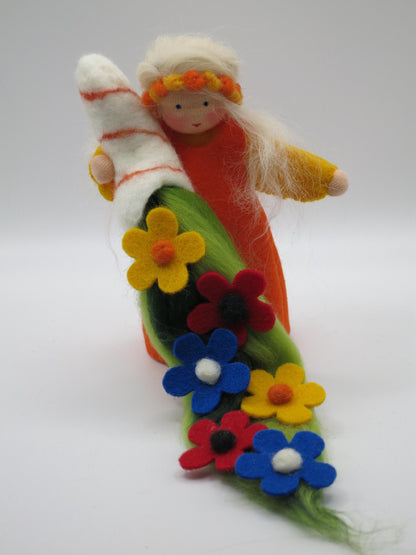 Sommer-Blumenkind mit orangefarbenem Gewand, hellem Filzzweig und langem Blumenteppich in kräftigen Sommerfarben