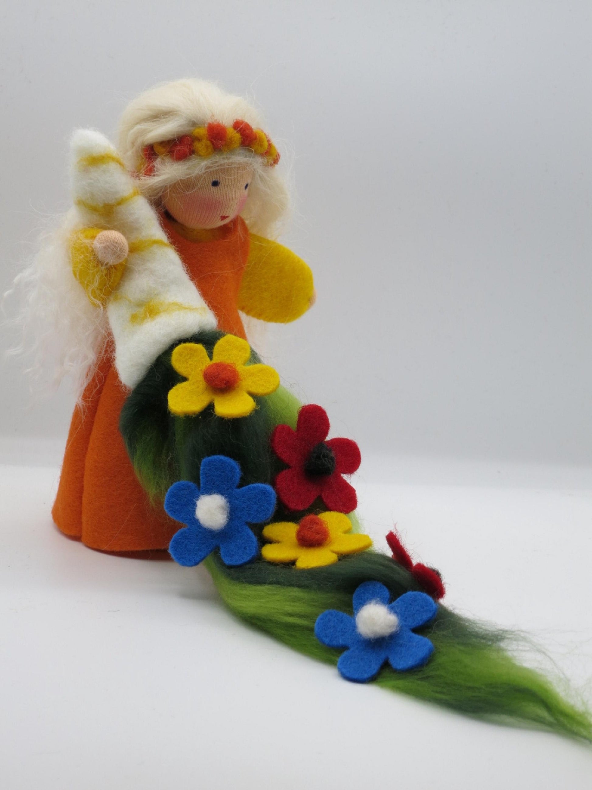 Seitliche Ansicht der Sommerfigur mit langem grünen Filzband und farbenfrohen Sommerblumen in Blau, Rot und Gelb