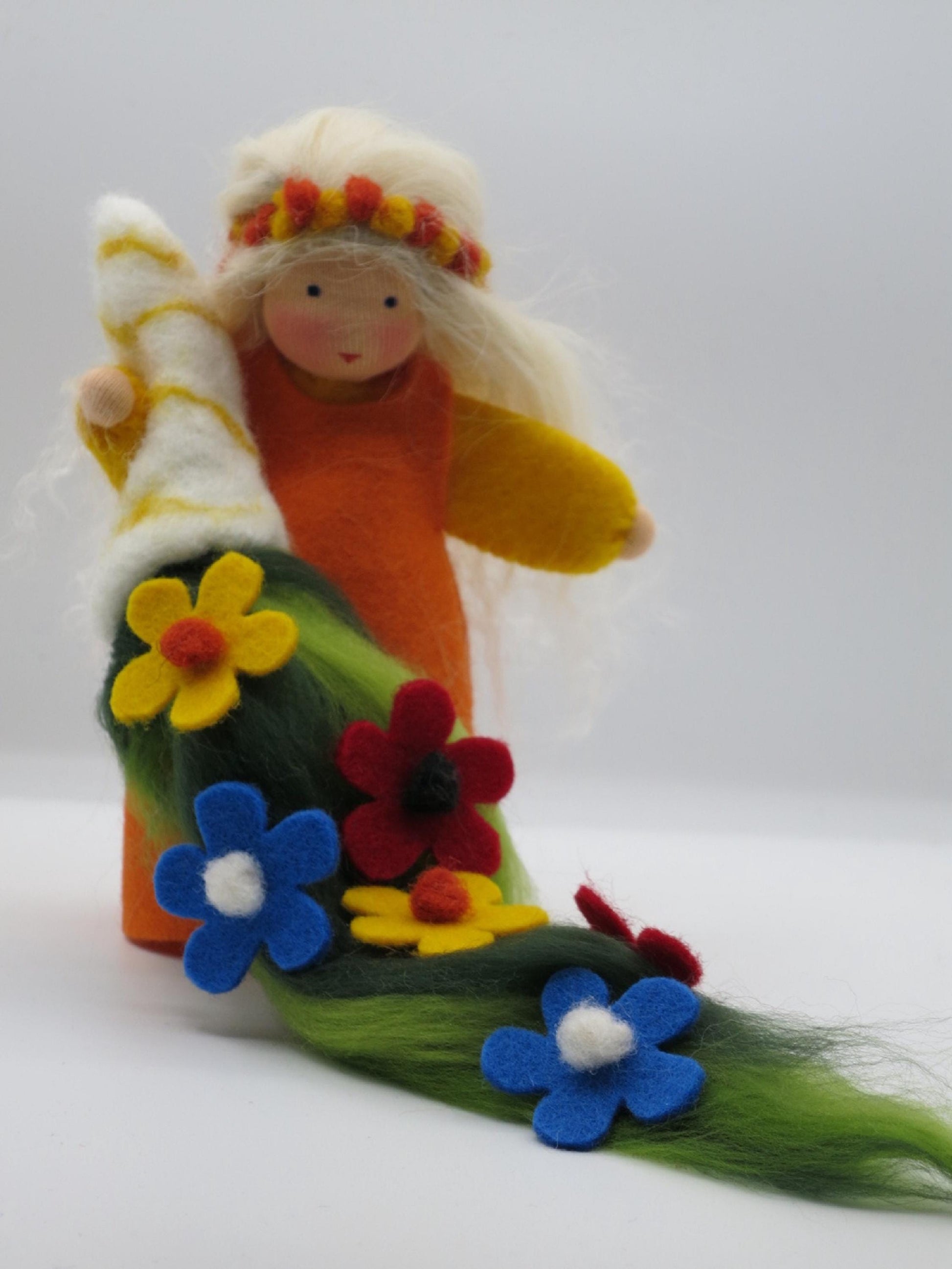 Handgefertigte Sommerfigur mit bunter Filzblumenwiese und orange-gelbem Gewand für den Waldorf-Jahreszeitentisch