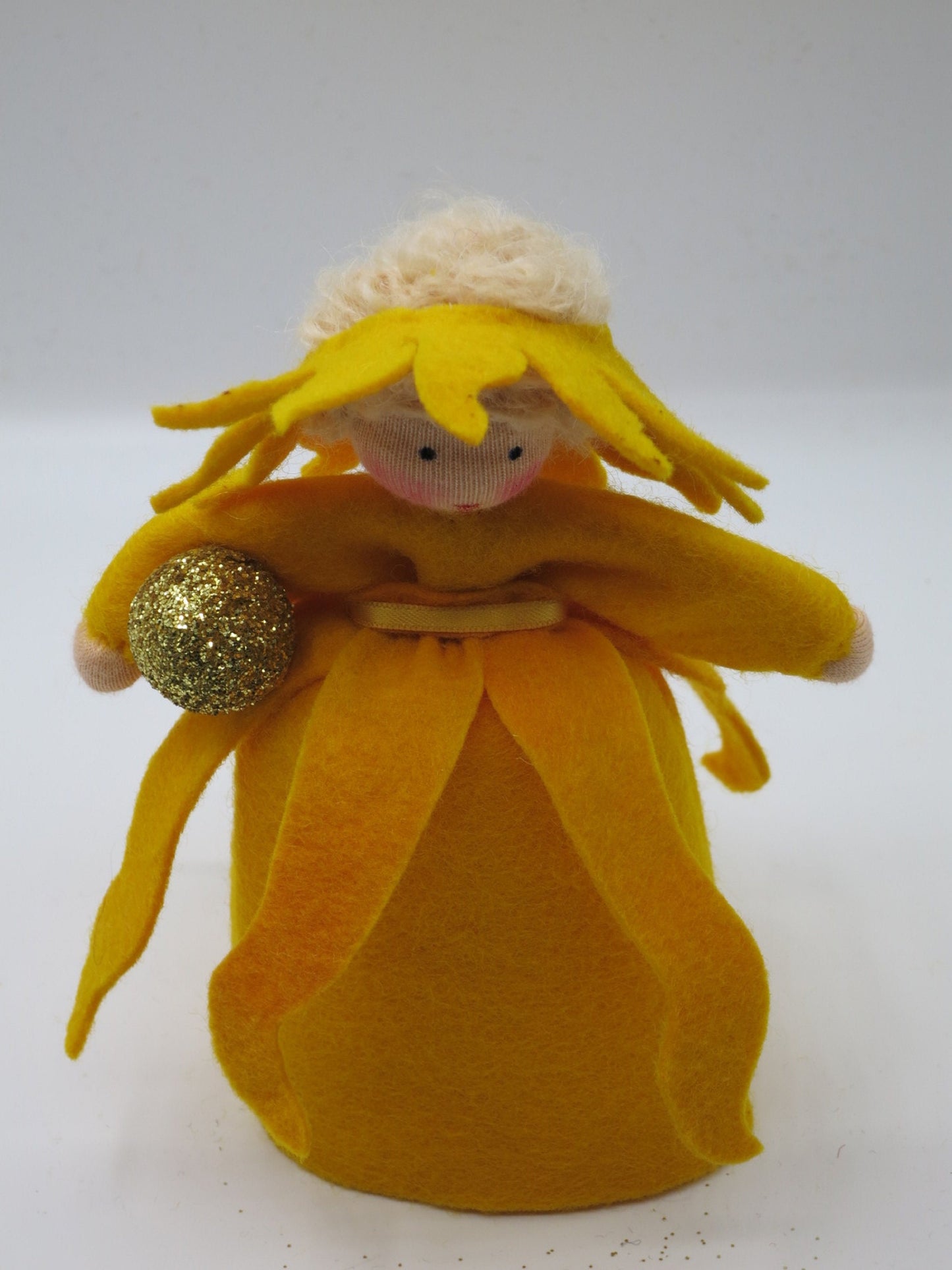 Sonnen-Mädchen-Blumenkind aus Wollfilz mit Sonnenkugel in der Hand, Frontalansicht.