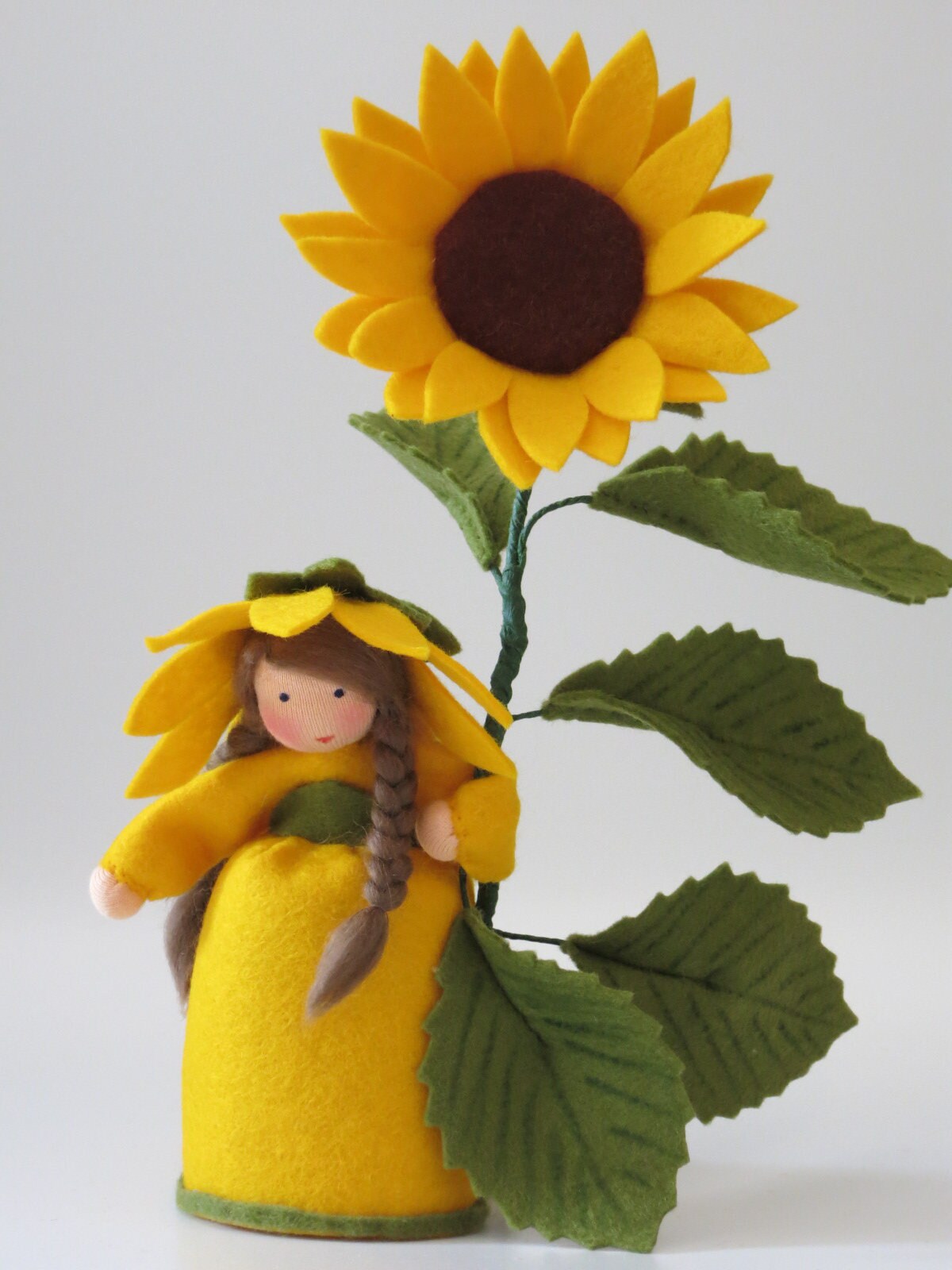 Sonnenblume-Blumenkind mit brauner Blütenmitte, Frontalansicht, Wollfilzfigur für den Waldorf Jahreszeitentisch.