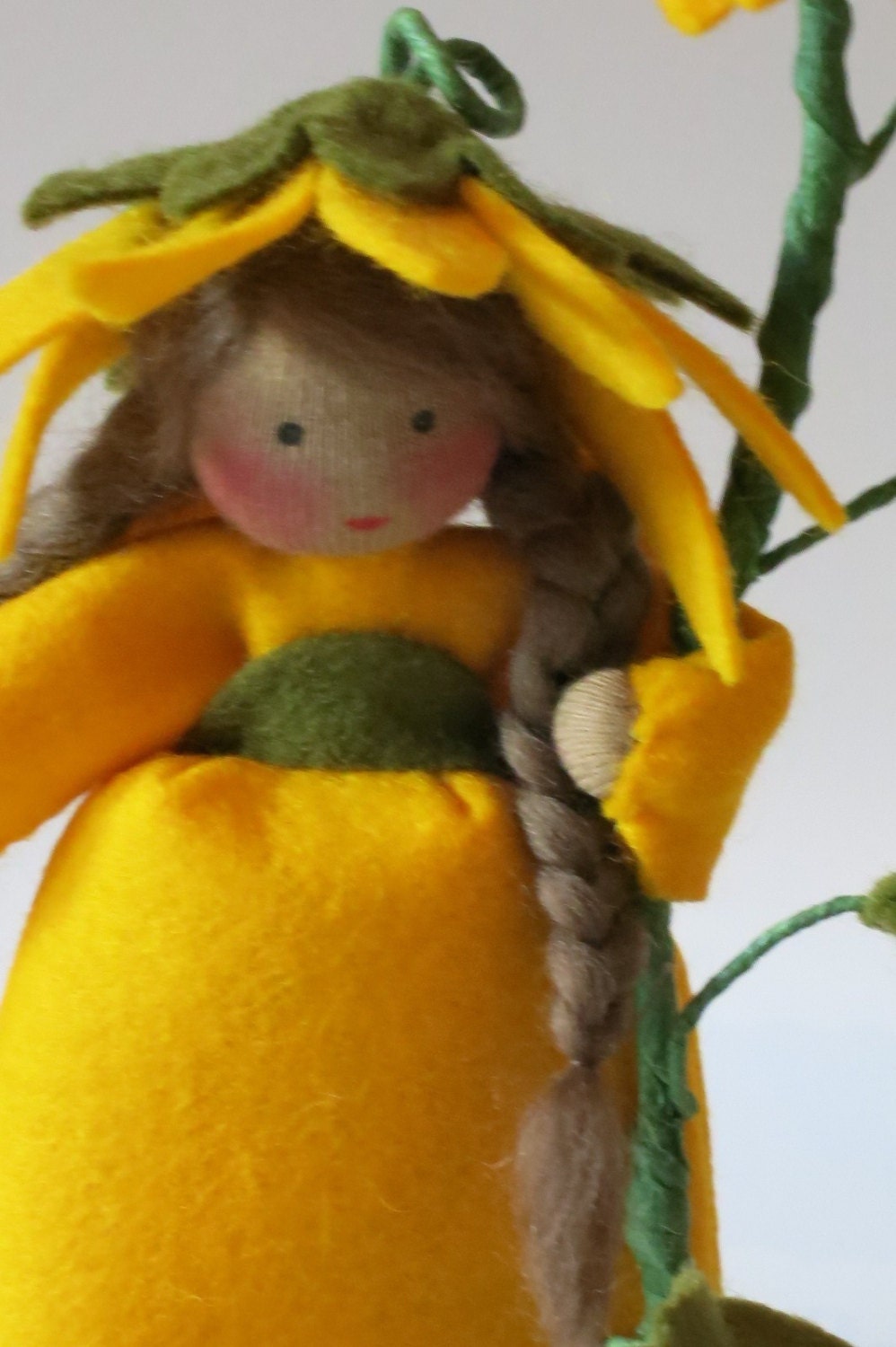 Nahaufnahme des Gesichts der Sonnenblumen-Figur unter gelben Blütenblattfalten.