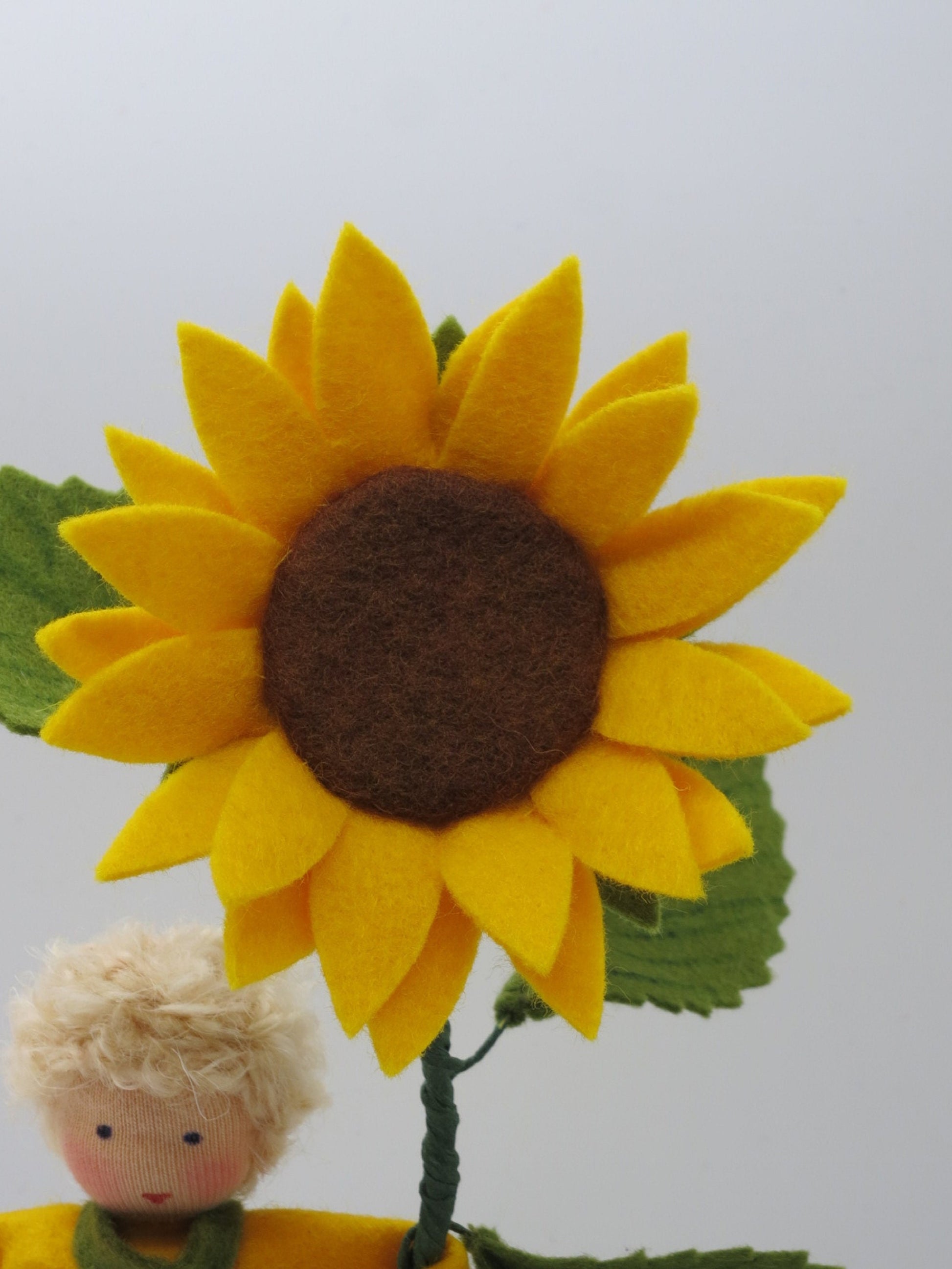 Frontalansicht der Sonnenblumenblüte am Wollfilz-Blumenkind, Waldorf Jahreszeitentisch.