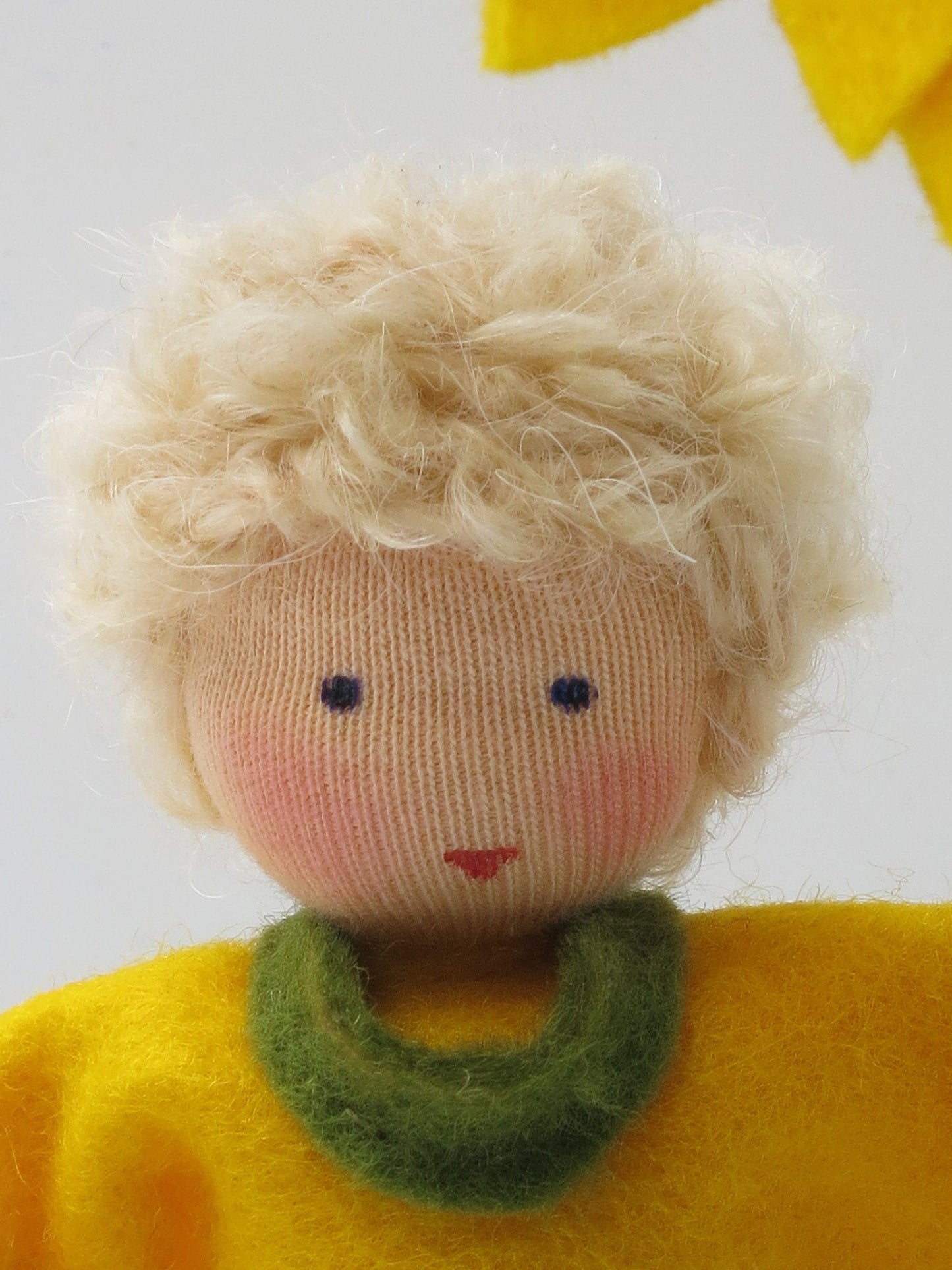 Porträt des Sonnenblumen-Jungen mit blondem Haar und grünem Kragen.