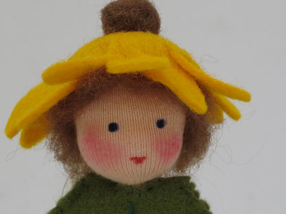 Porträt des Sonnenhut-Blätterkinds mit braunem Wollhaar, besticktem Gesicht und gelbem Filzblütenkranz.