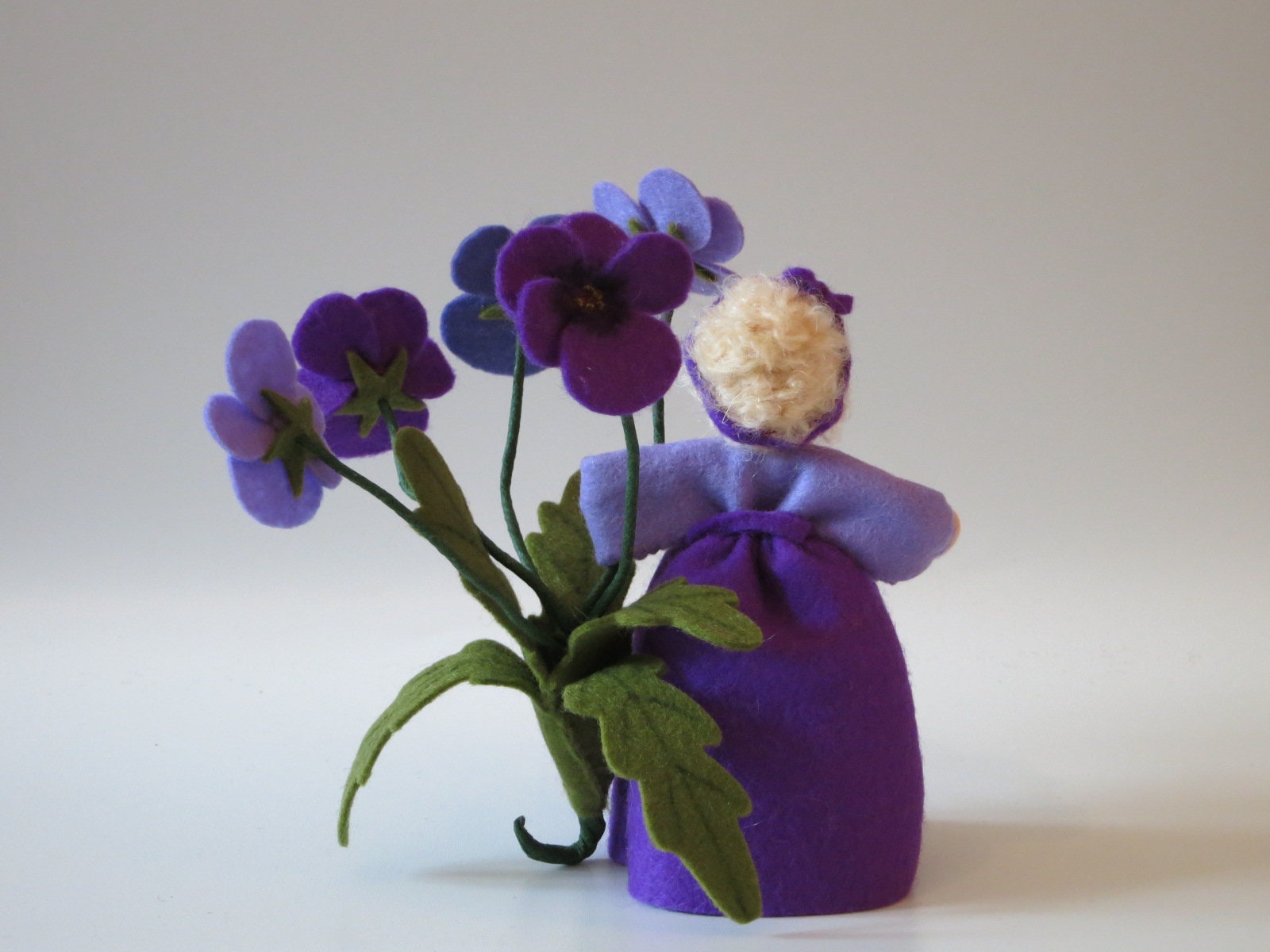 Gesamtansicht des Stiefmütterchen-Blumenkindes mit lila Kleid und Blütenzweigen