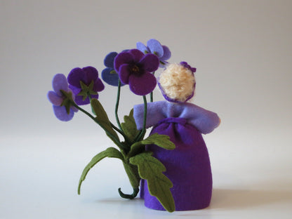 Gesamtansicht des Stiefmütterchen-Blumenkindes mit lila Kleid und Blütenzweigen