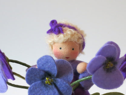 Nahaufnahme des Gesichts vom Stiefmütterchen-Blumenkind mit Blütenband im Haar