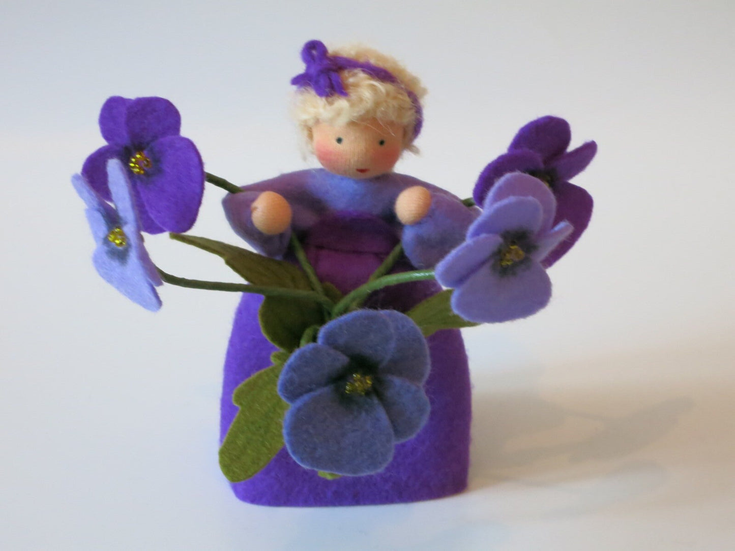 Stiefmütterchen-Blumenkind aus Wollfilz mit sieben Blüten in Violett- und Blautönen