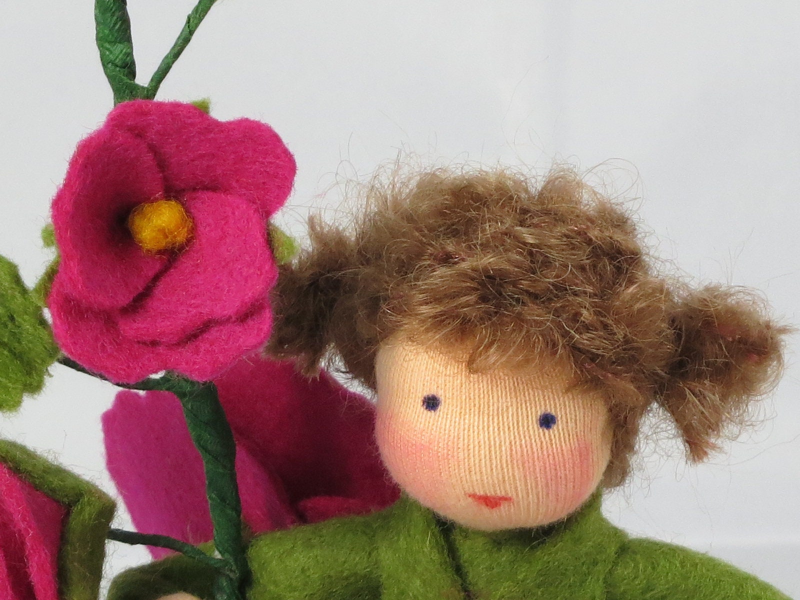 Seitliche Gesamtansicht des Stockrosen-Blumenkindes mit Blütenzweig