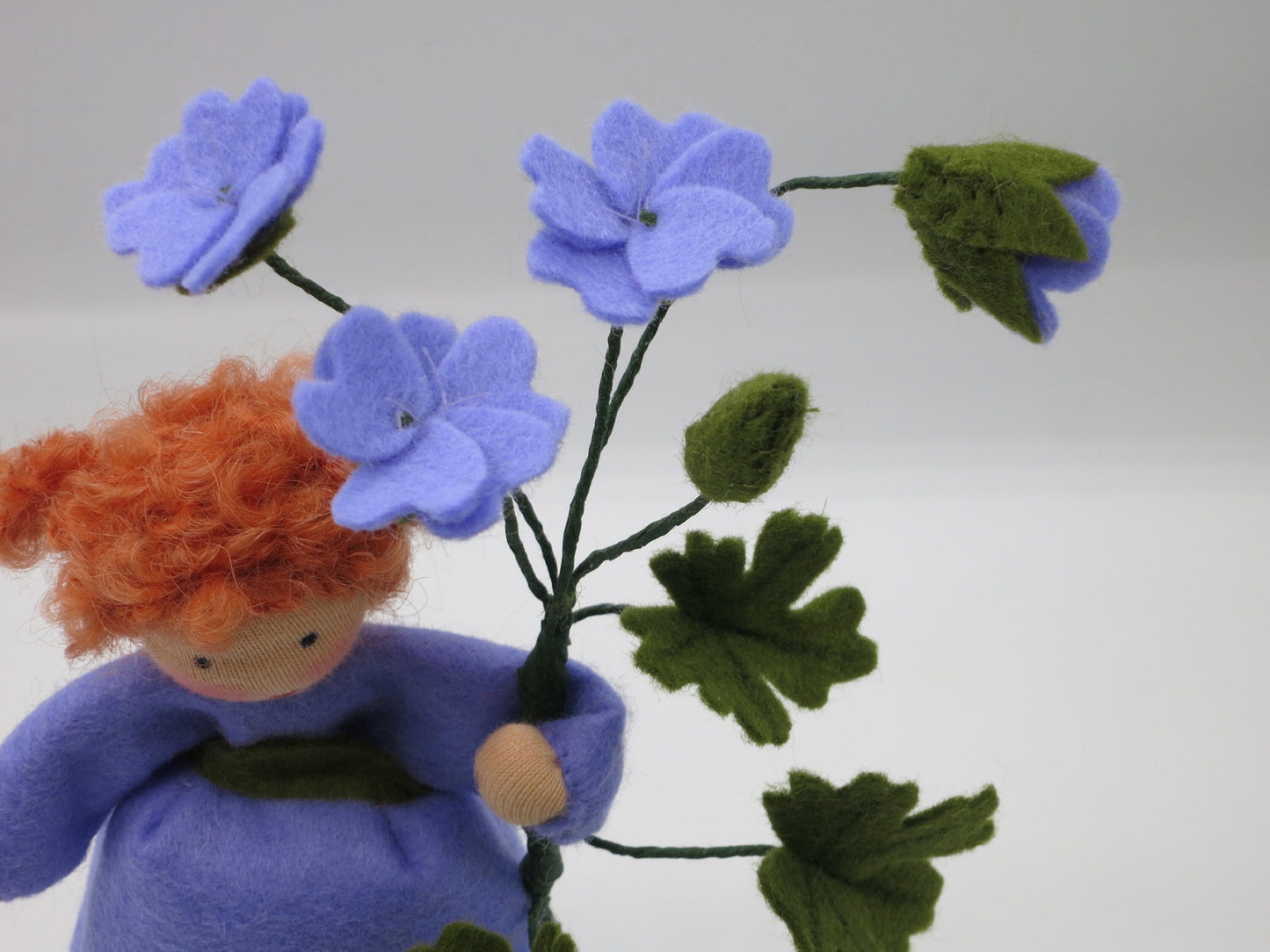 Nahaufnahme der violetten Storchschnabel-Blüten aus Filz mit fünf Blütenblättern.