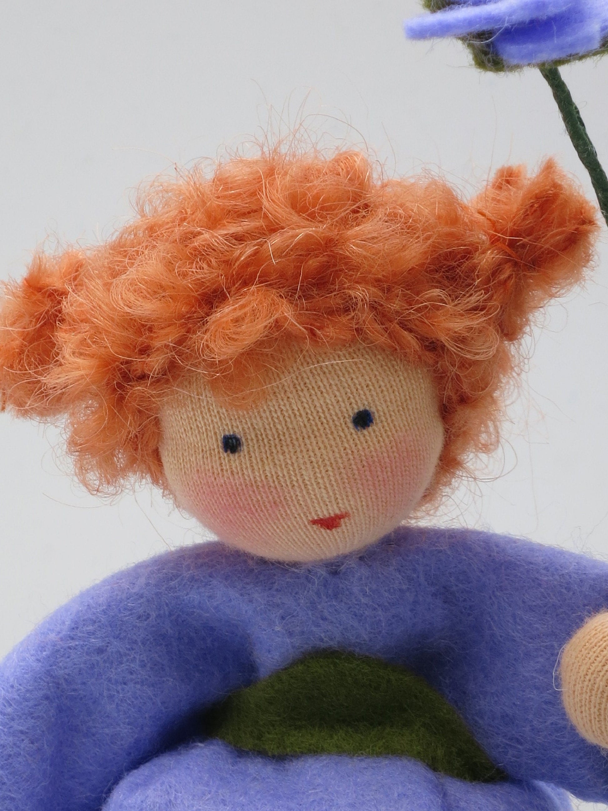 Nahaufnahme des Gesichts der Storchschnabel-Figur mit rotem Lockenhaar.