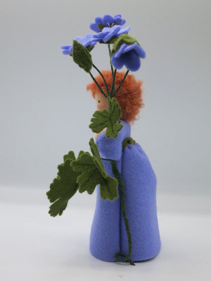 Porträt des Storchschnabel-Blumenkindes mit rotem Lockenhaar und violettem Filzkleid.