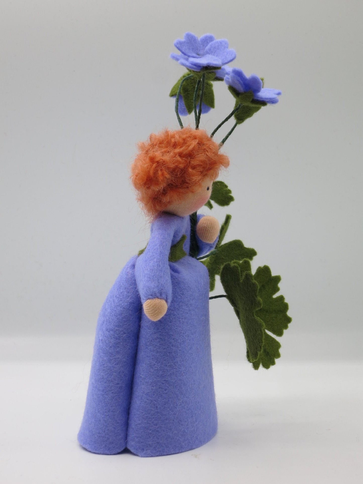 Rückansicht des Storchschnabel-Blumenkindes mit violetten Blüten und gelapptem Blatt.