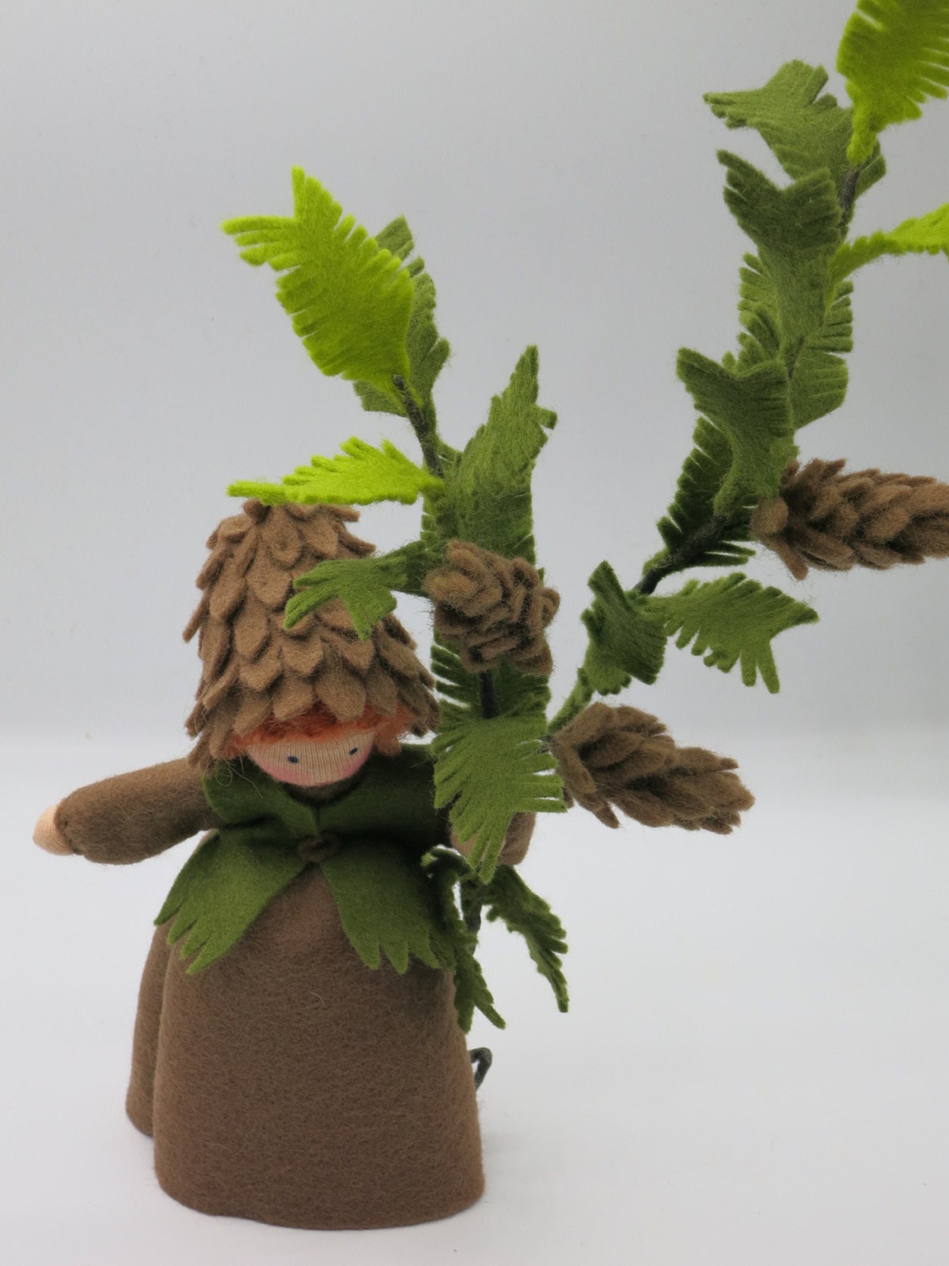 Tannenzapfen-Kind Blumenkind aus Wollfilz, Nahaufnahme mit Zapfenhaube und Tannenzapfen am Zweig, Waldorf-Jahreszeitentisch, Art. HE26