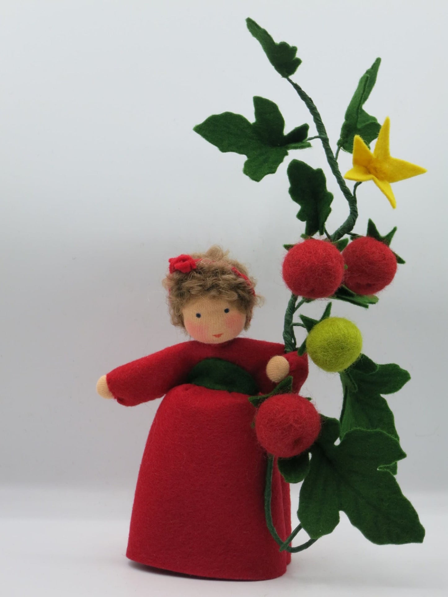 Tomaten-Blumenkind aus Wollfilz mit drei roten Tomaten, einer grünen unreifen Frucht und gelber Blüte