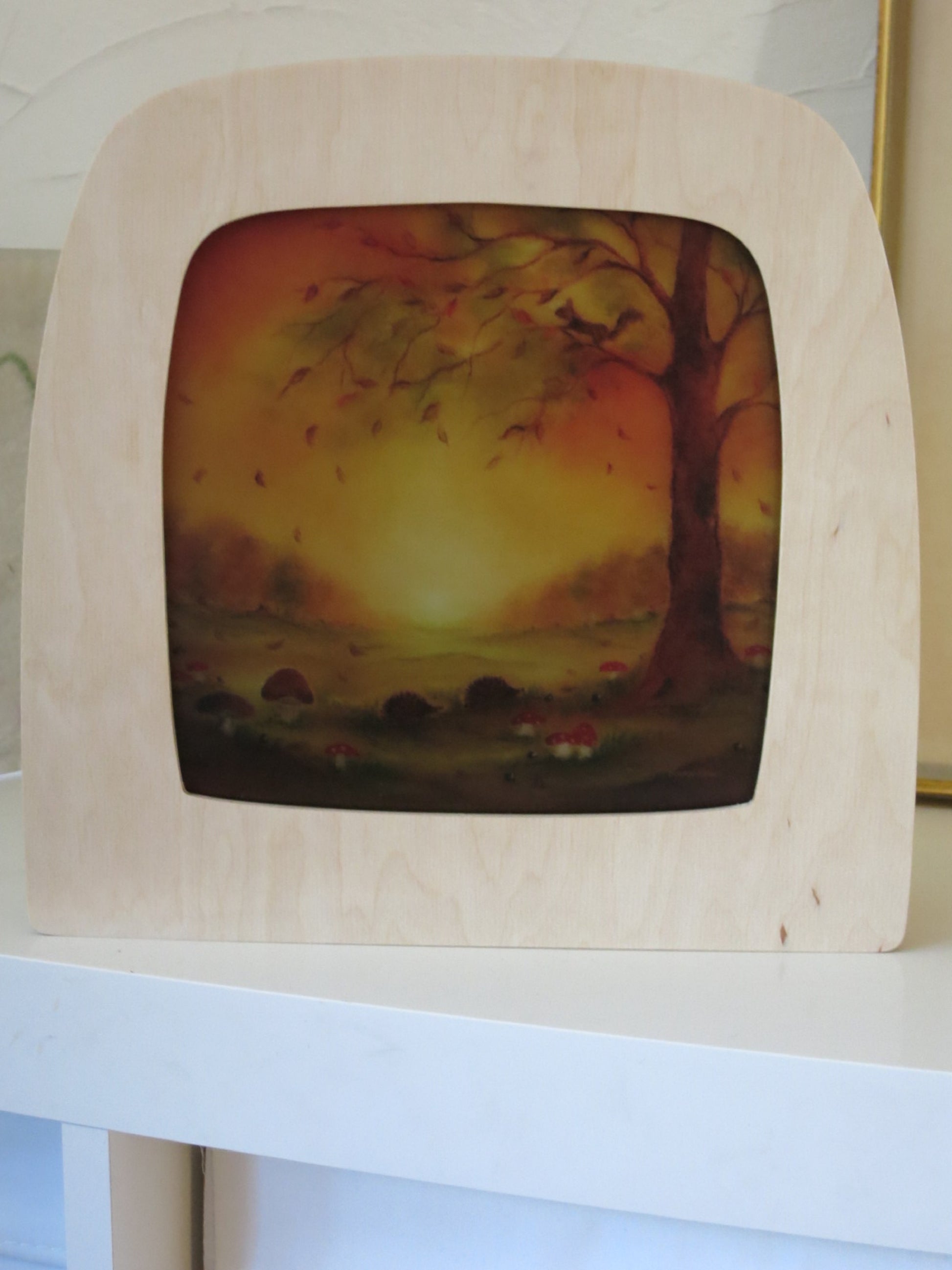 Toverlux Holzlampe mit Herbstmotiv als Nachtlicht auf einem weißen Regal