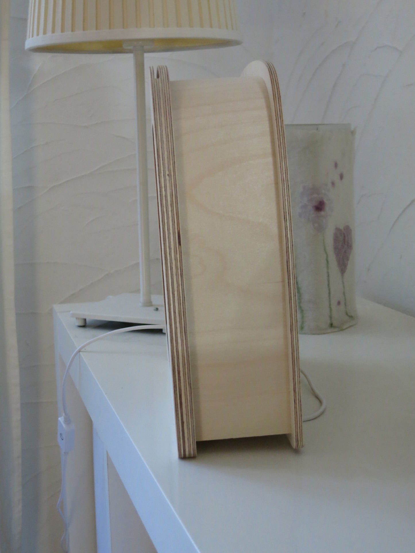 Seitenansicht der schlanken Toverlux Holzlampe im Größenvergleich neben einer Tischlampe