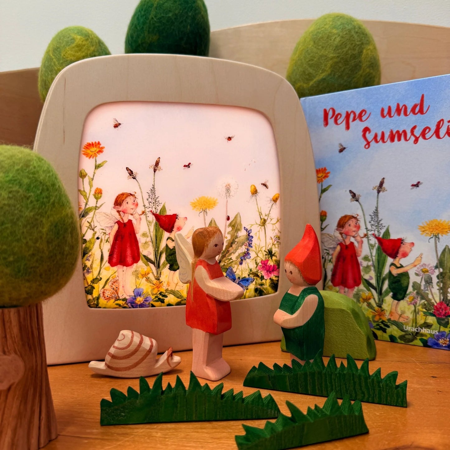 Toverlux Rahmen mit Pepe-und-Sumselinchen-Motiv, dekoriert mit Holzfiguren und dem gleichnamigen Bilderbuch