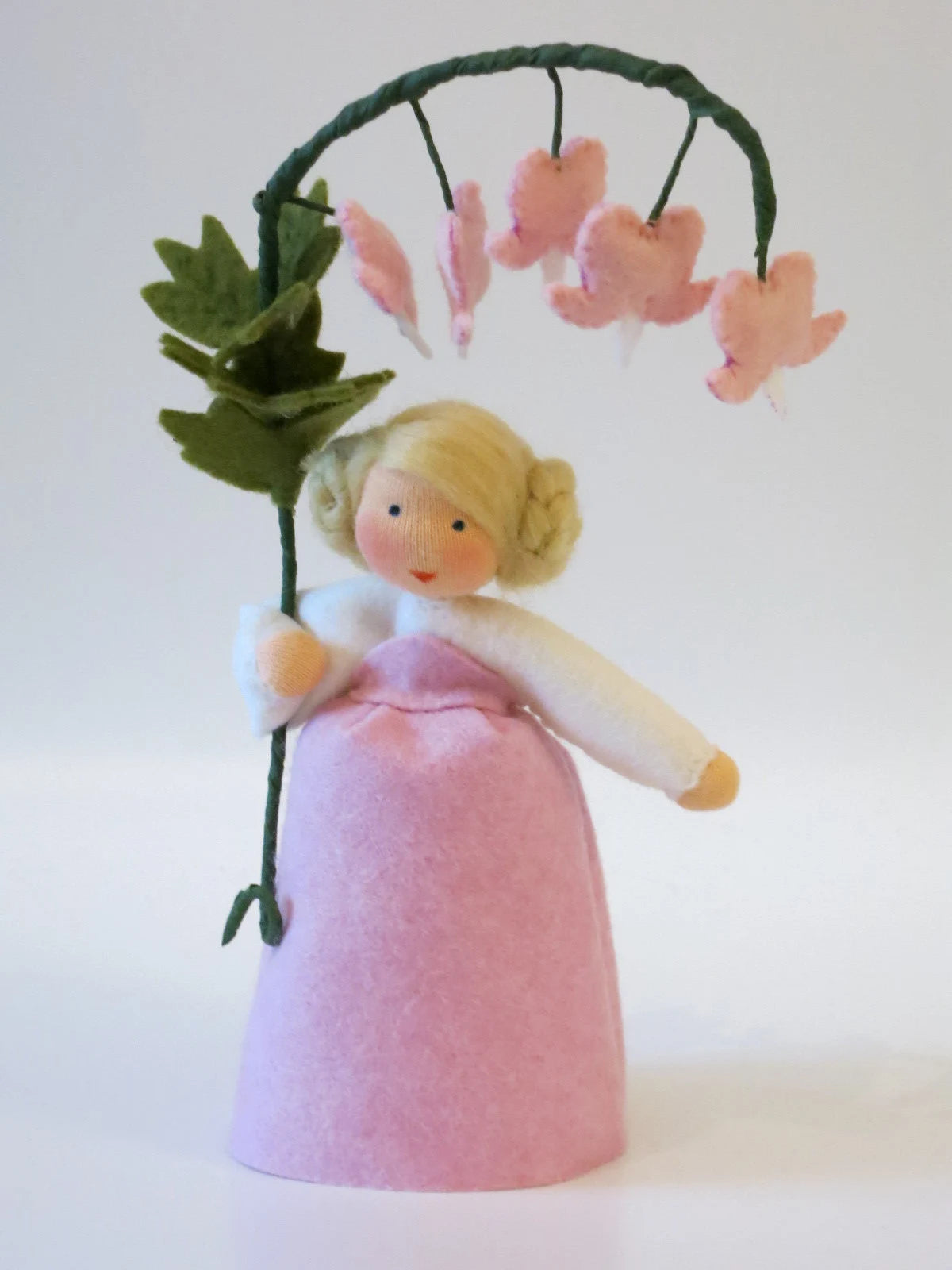 Frontalansicht des Tränendes-Herz-Blumenkinds mit geflochtenen Zöpfen und rosa Kleid
