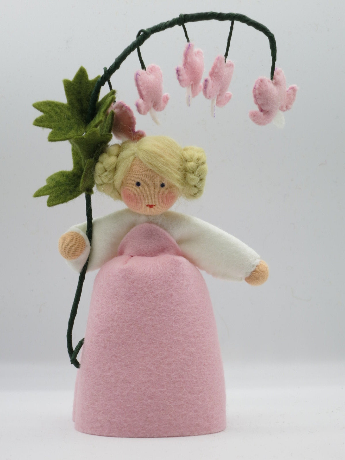 Tränendes Herz Blumenkind aus Wollfilz für den Waldorf Jahreszeitentisch mit rosa Herzblüten am gebogenen Blütenzweig