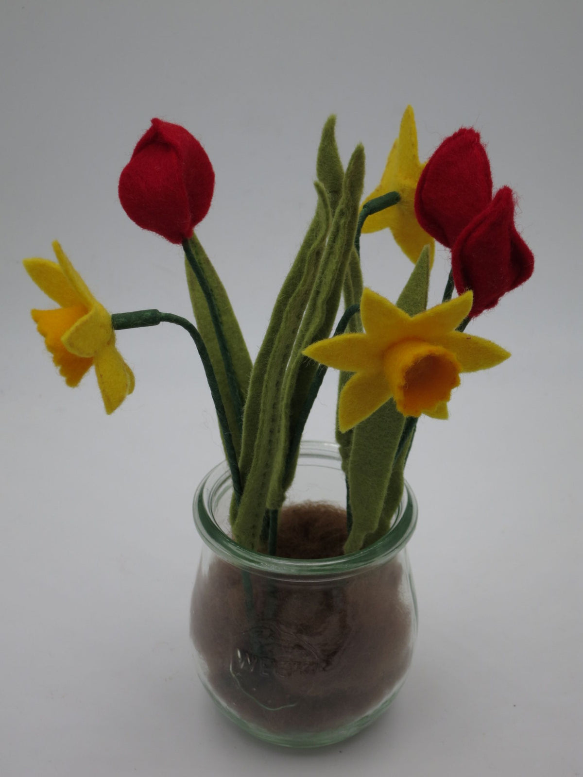 Seitenansicht der Filz-Frühlingsdeko im Glas mit roten Tulpen und gelben Narzissen