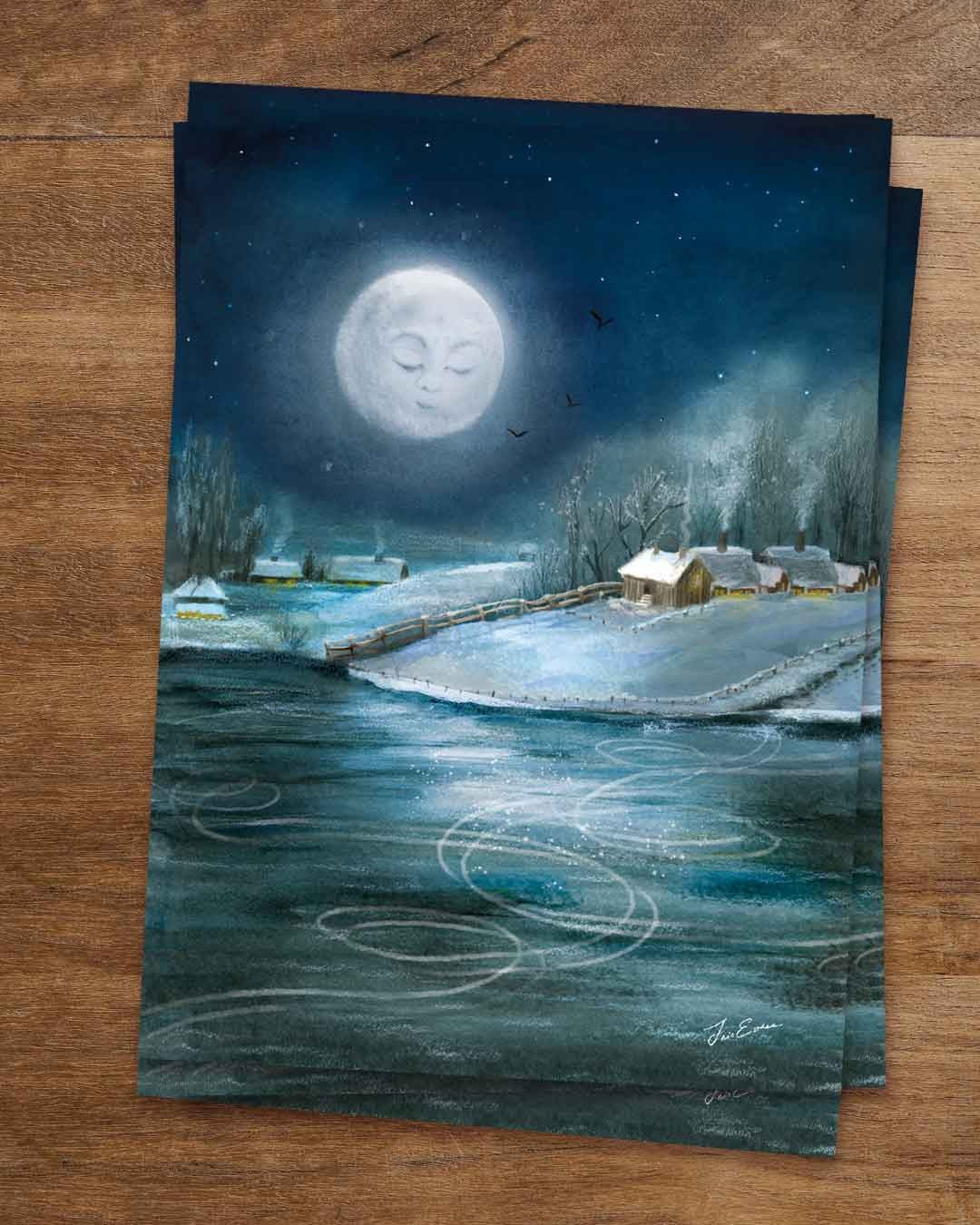 Postkarte „Unter dem Wintermond“ von Iris Esther: großer Vollmond mit geschlossenen Augen am Nachthimmel, drei Vögel, darunter verschneite Höfe mit erleuchteten Fenstern und Holzzaun, im Vordergrund ein zugefrorener See mit geschwungenen weißen Schlittschuhspuren