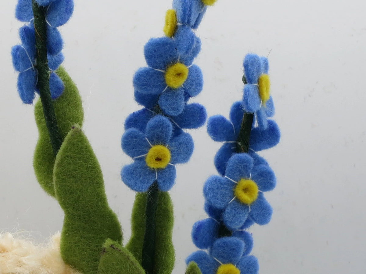 Detailansicht der blauen Vergissmeinnicht-Blüten aus Filz mit gelber Mitte am Blumenkind