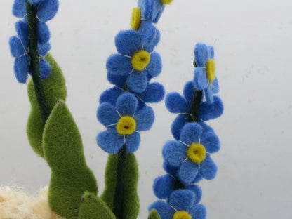 Detailansicht der blauen Vergissmeinnicht-Blüten aus Filz mit gelber Mitte am Blumenkind