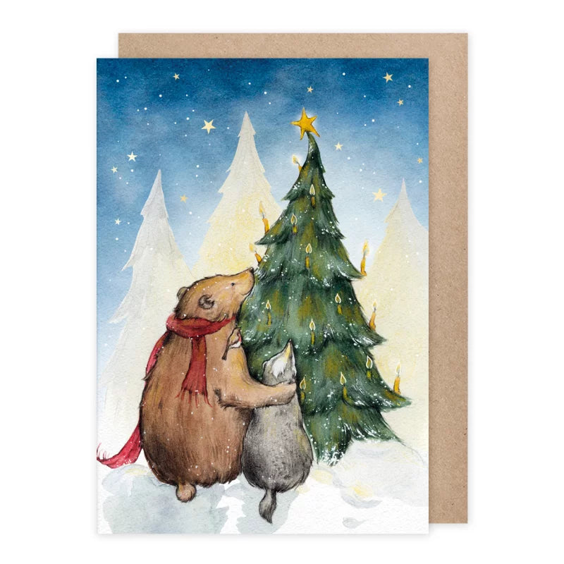 Weihnachtskarte Bär umarmt Dachs vor dem Weihnachtsbaum, Sternenhimmel