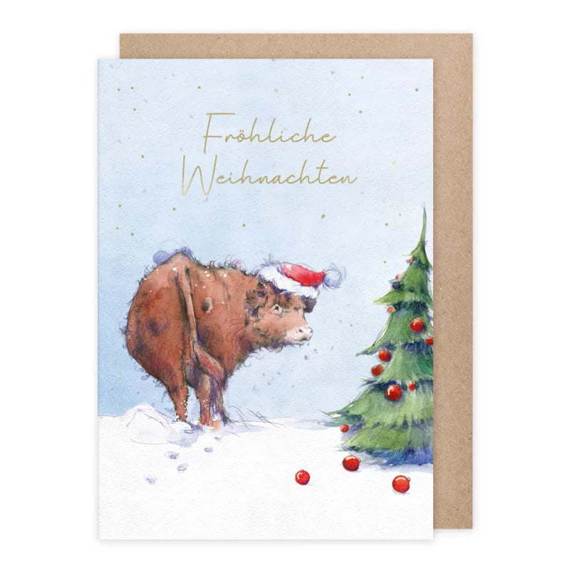 Weihnachtskarte zotteliges Hochlandrind mit Weihnachtsmannmütze vor Tannenbaum