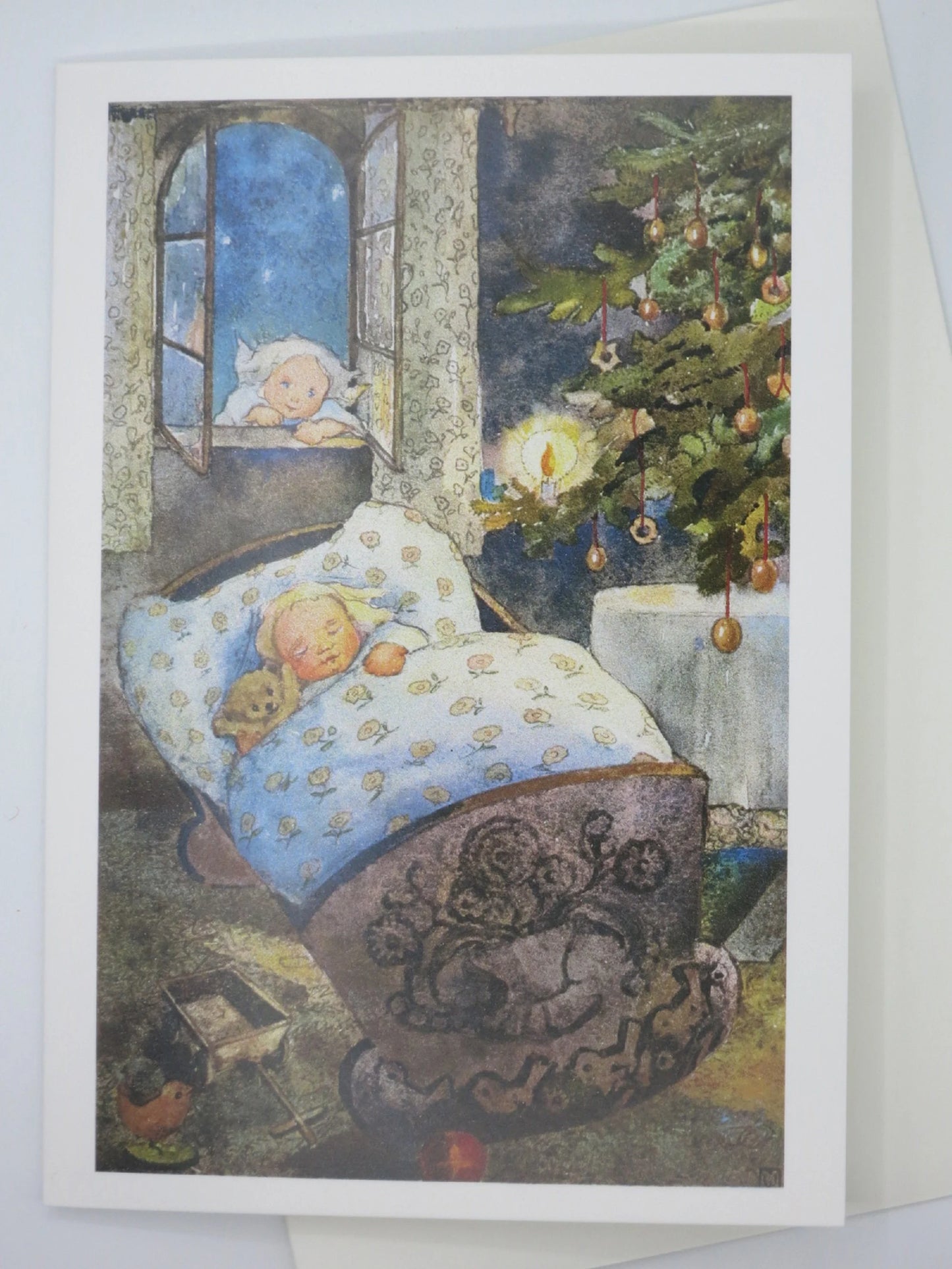 Weihnachtskarte schlafendes Kind in geschnitzter Wiege am Weihnachtsbaum