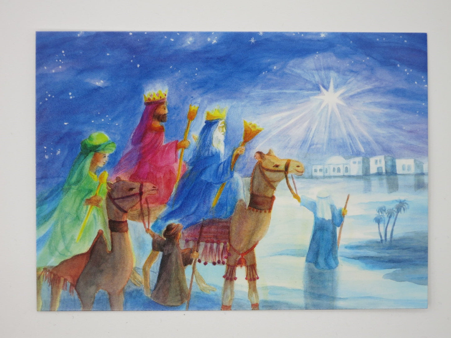 Weihnachtspostkarte für Kinder: Drei Koenige auf Kamelen folgen dem Stern zur fernen Stadt