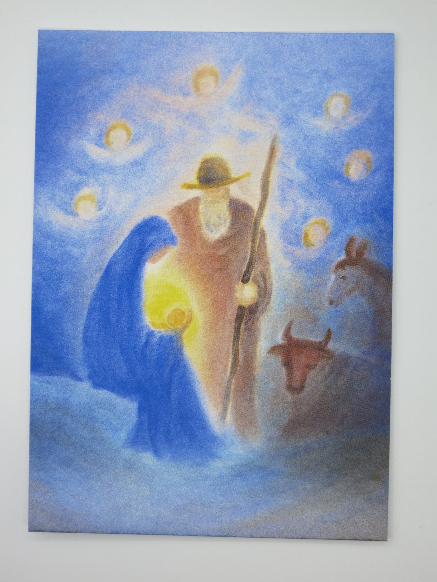 Weihnachtspostkarte für Kinder: Krippenszene mit Maria, Josef und leuchtendem Jesuskind, Engel am Nachthimmel