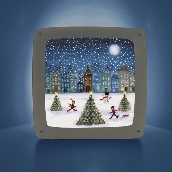 Weihnachtliches Schlittschuhlaufen Toverlux Motiv MO3: Kinder mit Schlitten zwischen Weihnachtsbäumen und Schneemann vor beleuchteten Grachtenhäusern bei Vollmond – für die Magische Lampe