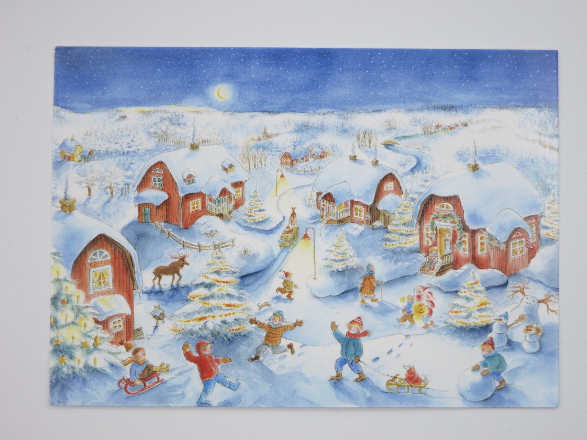 Kunstpostkarte Weihnachtszeit von Dorle Schausbreitner – verschneites Dorf mit spielenden Kindern, PKWI79