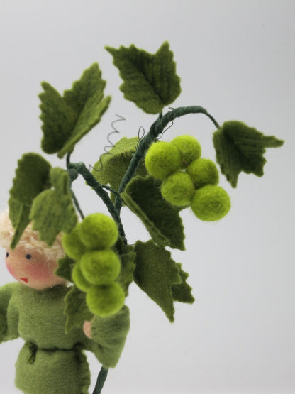 Gruene Weintrauben aus gefilzten Wollkugeln mit Weinlaub und Ranke in Nahaufnahme, Herbst-Blumenkind, Art. HE59