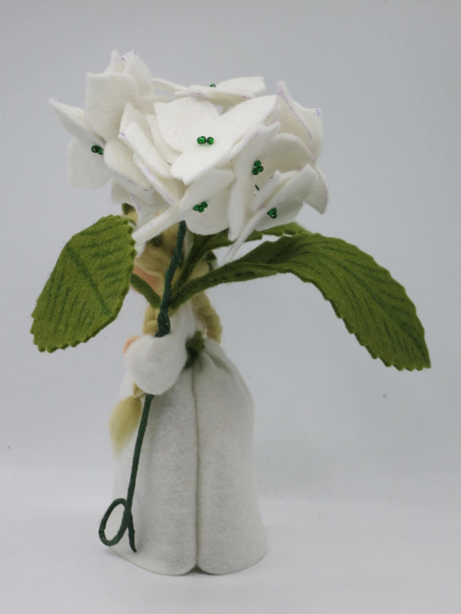 Rückansicht des weißen Hortensie-Waldorf-Blumenkindes mit blondem Zopf