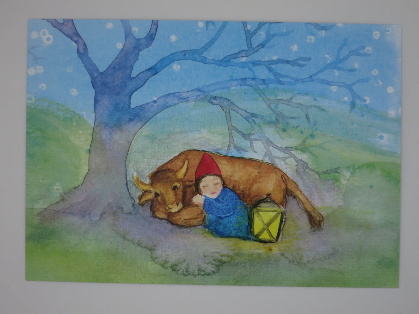 Postkarte Wicht und Ochse von Anna Hunold, schlafender Wicht lehnt an ruhendem Ochsen unter Baum
