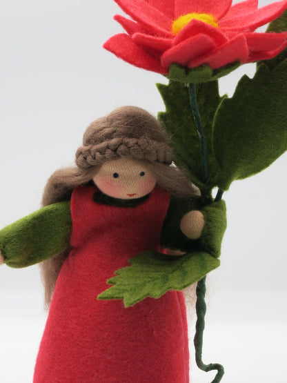 Detailaufnahme des Gesichts unter der roten Dahlienblüte am Blumenkind Art. HE50, Waldorf-Jahreszeitentisch.
